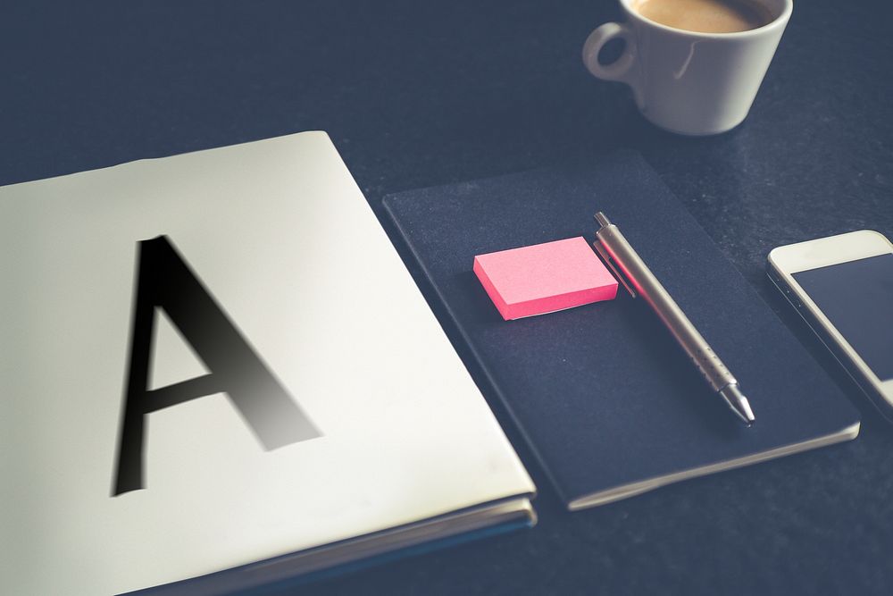 A notebook with letter a on a dark table