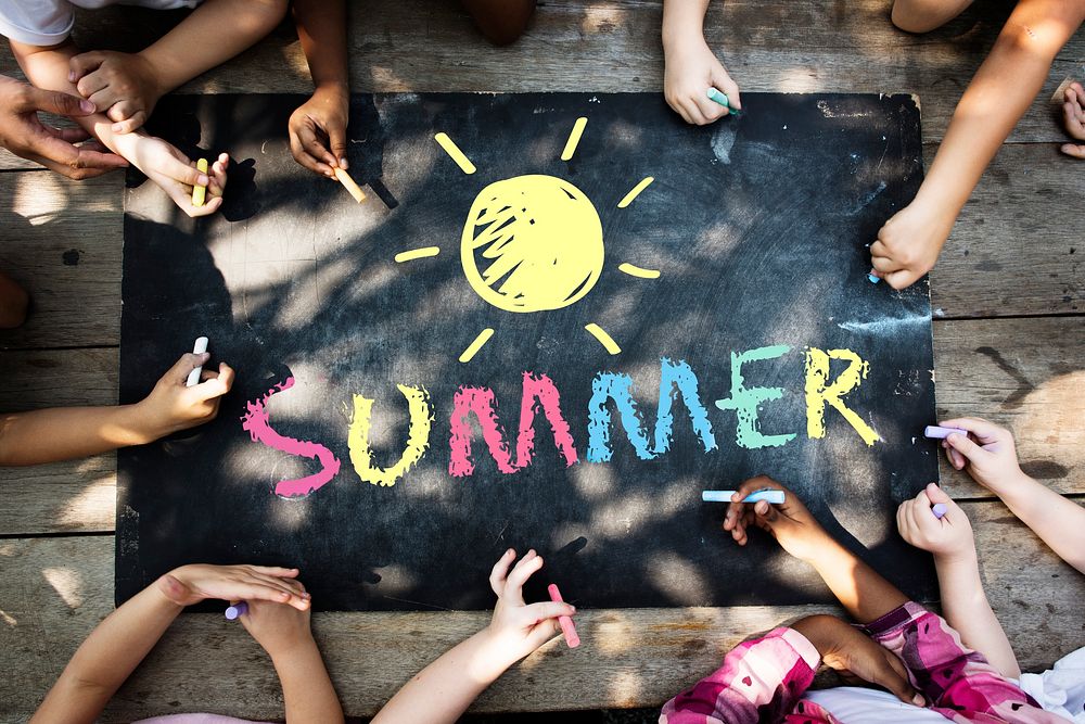Group of kids writing summer on a chalkboard