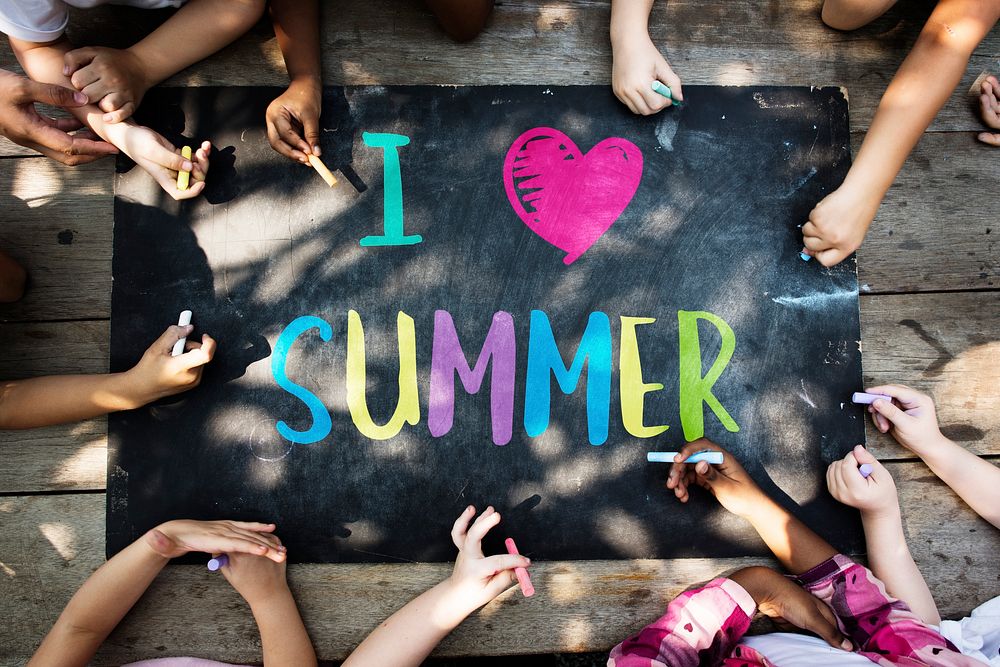 Group of kids writing summer on a chalkboard