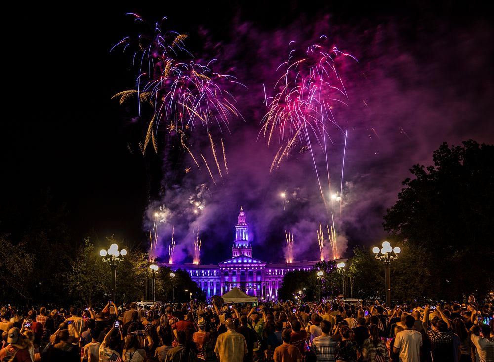 Colors of the illuminated Civic Center in downtown Denver mirror many of those in the fireworks overhead at the annual…