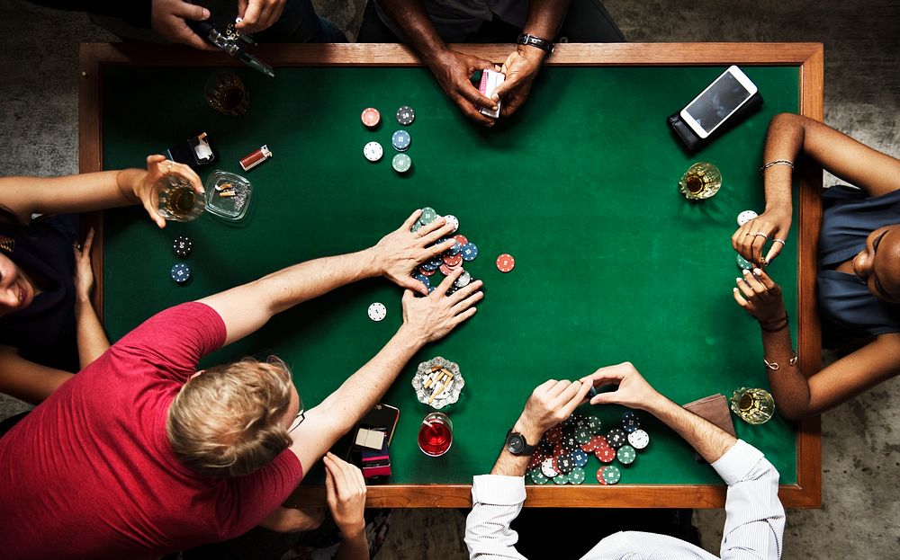 Diverse group playing poker and socialising 