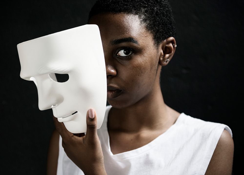 Thoughtful woman holding white mask
