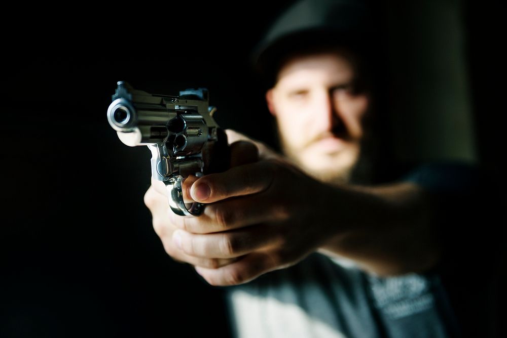 Man holding a gun with black background