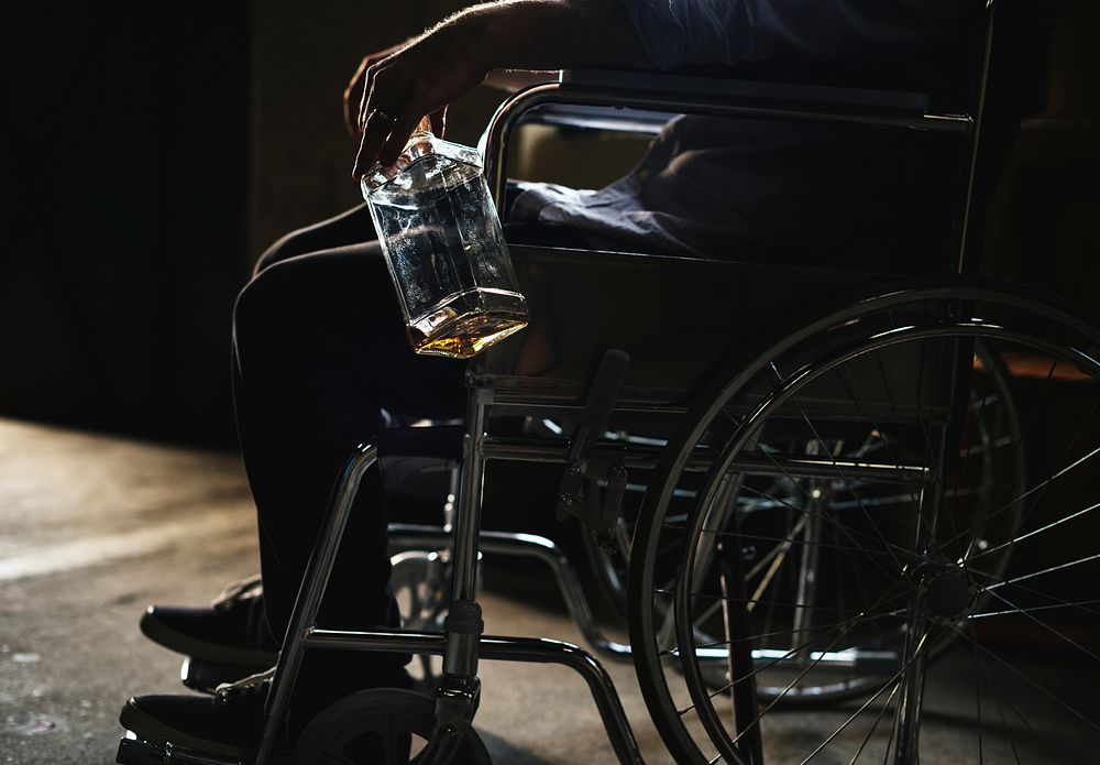 Alcoholic man sitting in a wheelchair