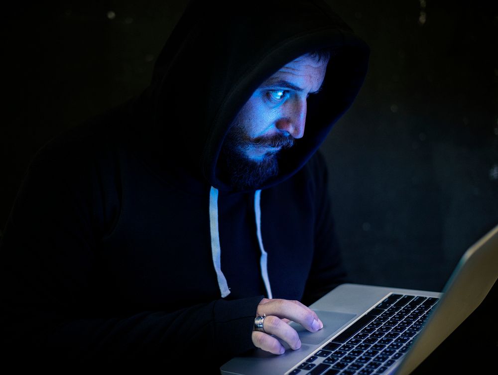 Computer hacker using a laptop
