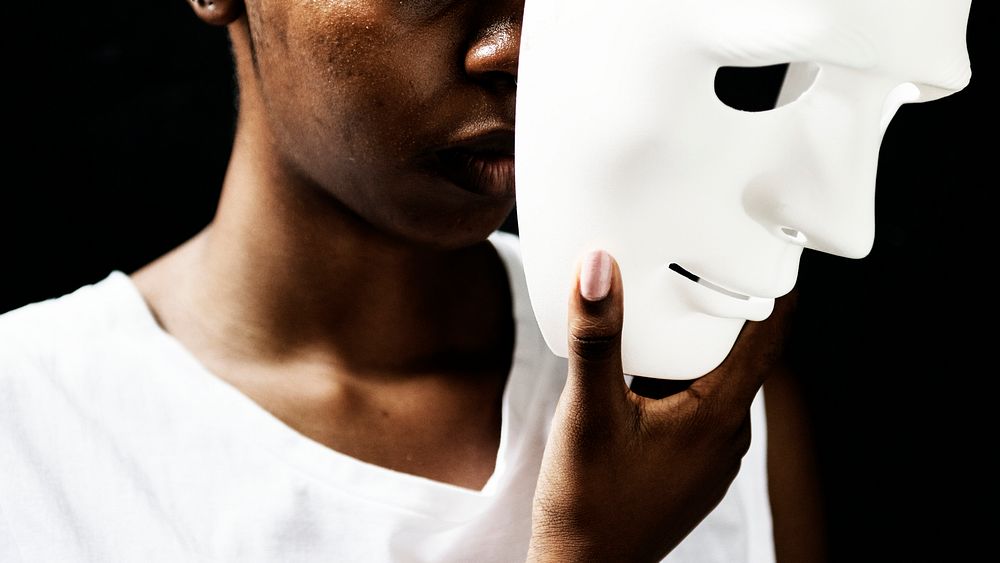 African woman holding white mask