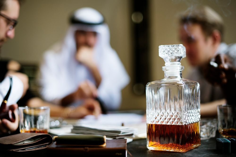 Whiskey decanter with business people in the background 