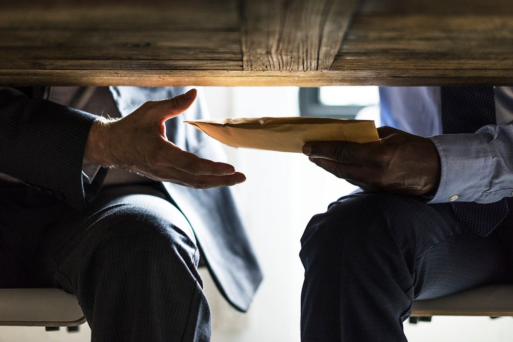Business people sending documents under the table