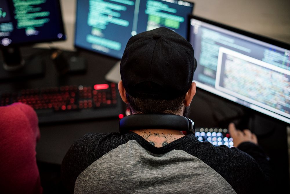 Caucasian tattooed man working on coding 