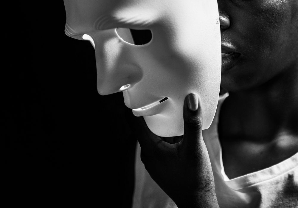 Black woman holding a white mask