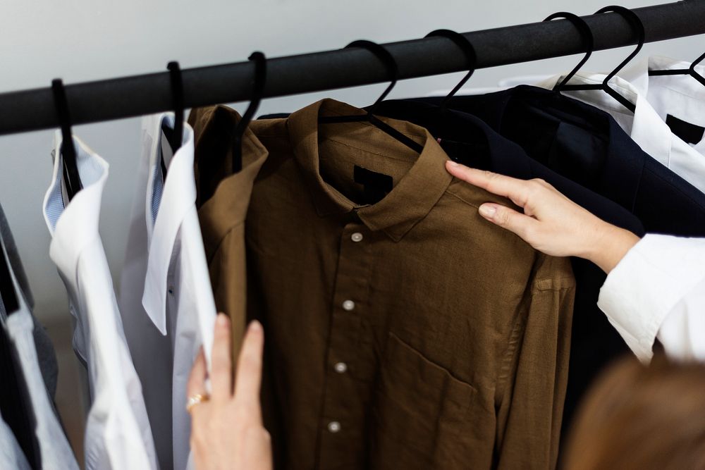 A stylish is choosing cloth from the rack
