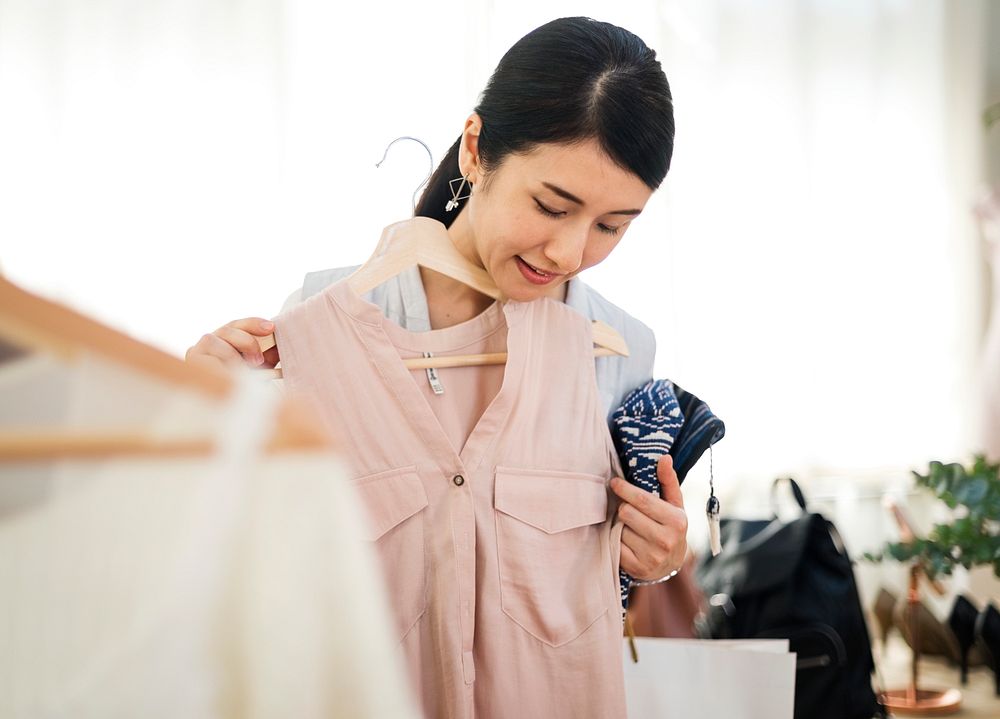 A stylish is choosing cloth from the rack