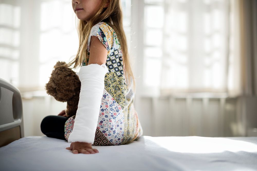 Young Caucasian girl with broken arm in plaster cast