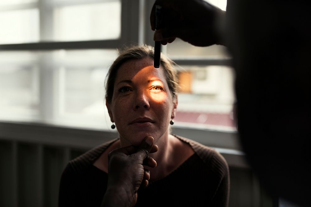 A Caucasian woman is getting eyes examine 