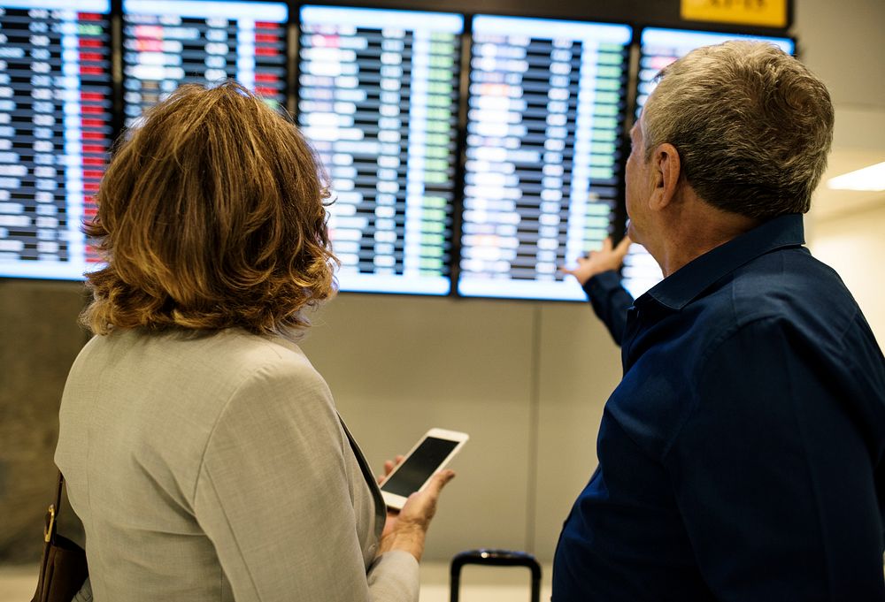 Caucasian couple is checking flight time schedule