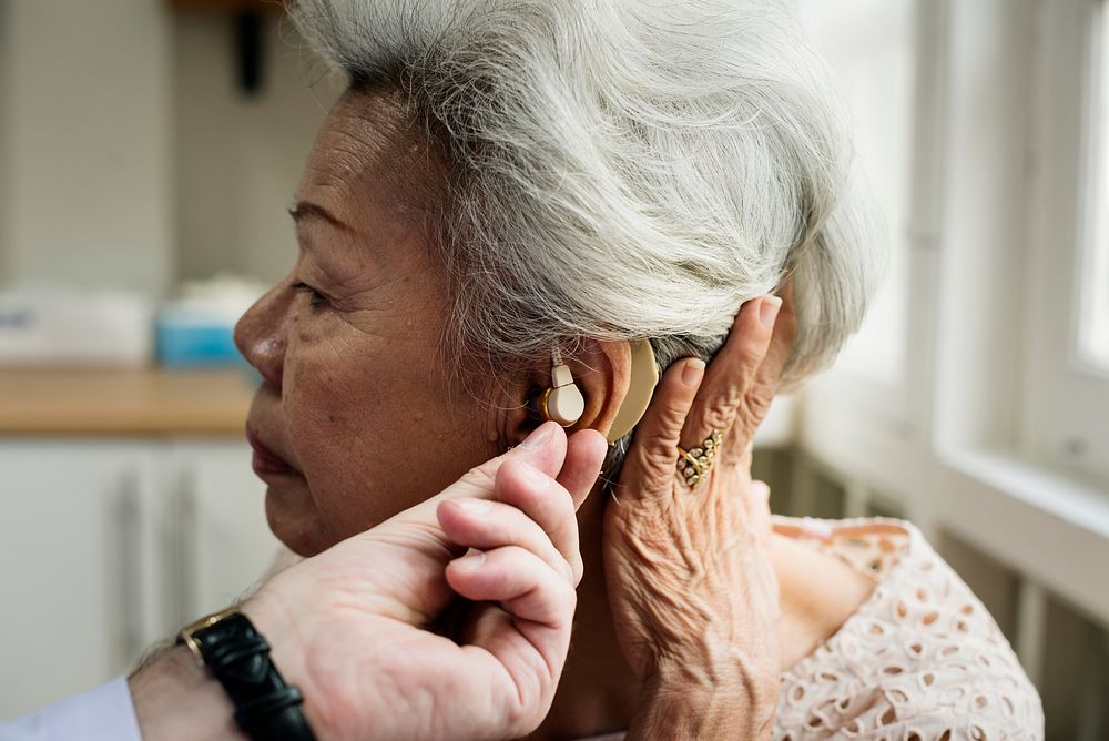 An elderly woman with hearing aid