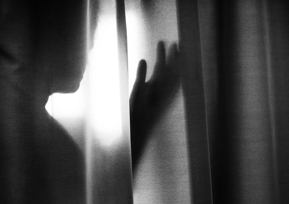 Human shadow behind a curtain