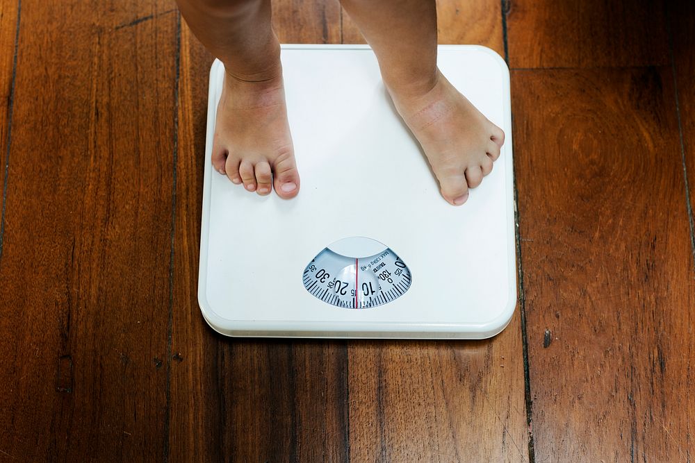 Closeup of kid legs on weight scale