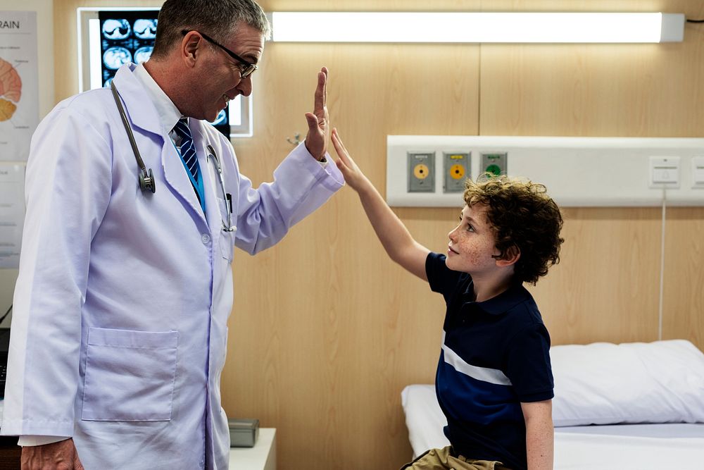 Young patient boy giving a doctor hi five