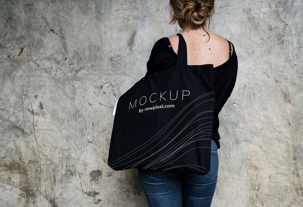 Woman carrying a black tote bag mockup