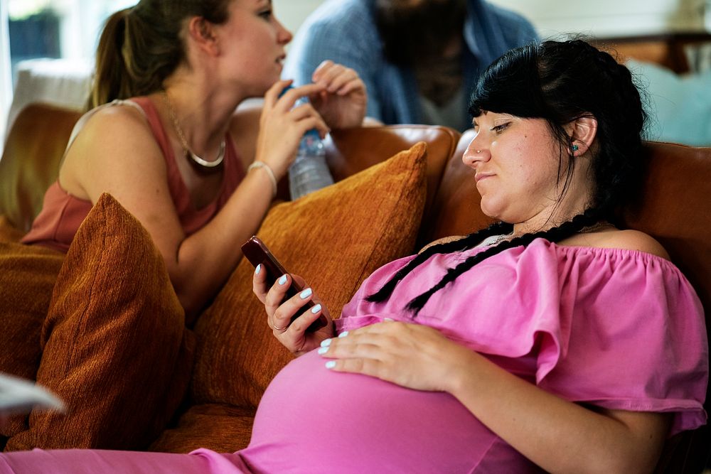 A pregnant lesbian woman sitting on a couch
