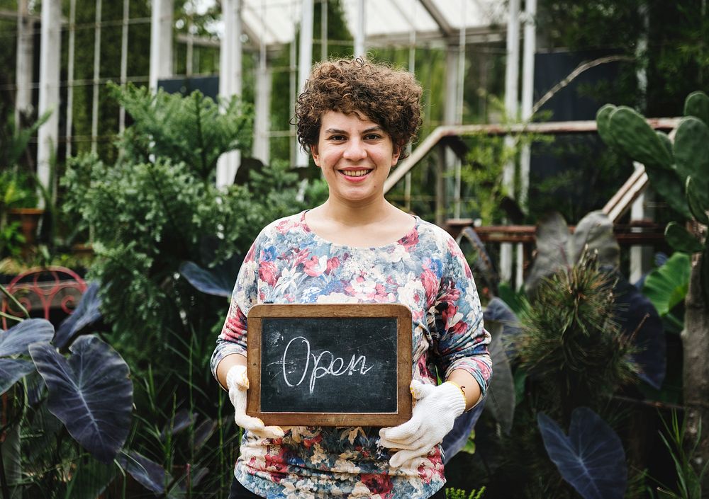 Garden shop owner holding an open sign