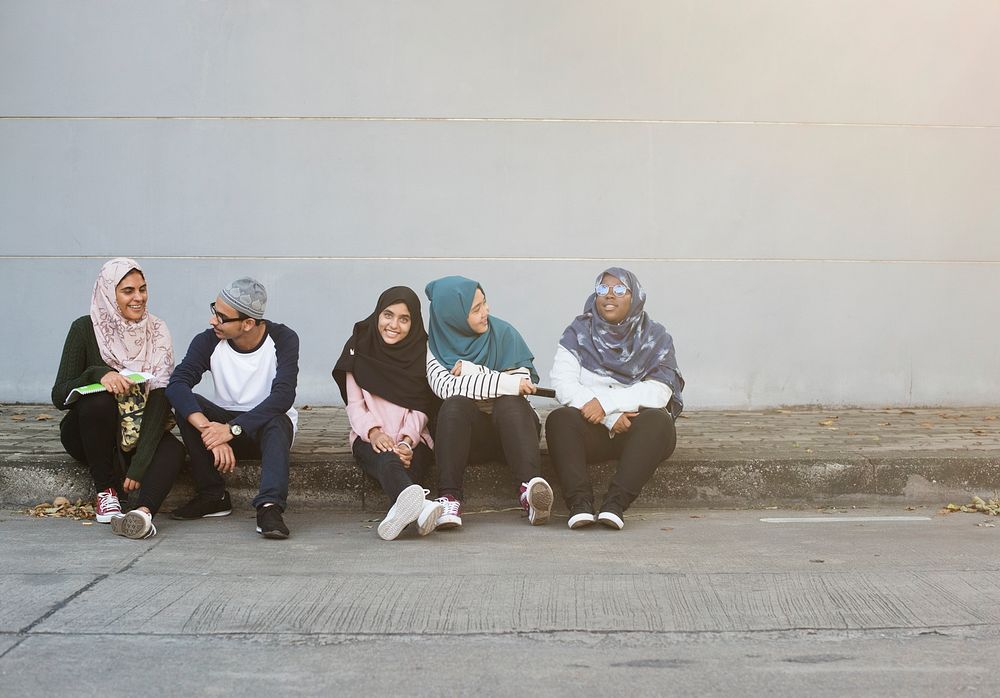 Female Muslim friends sitting together outdoor