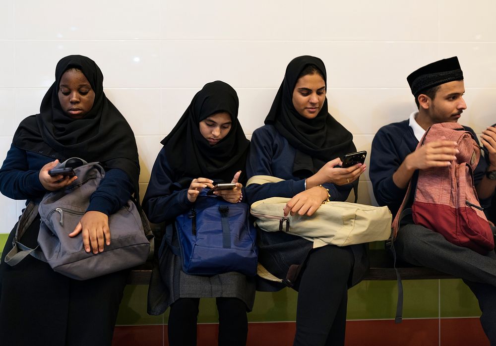 Group of diverse students using mobile phones