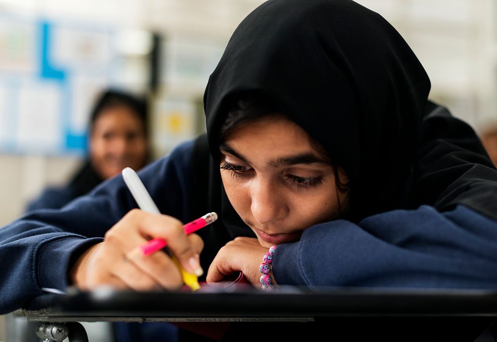 Young Muslim student studying in a class