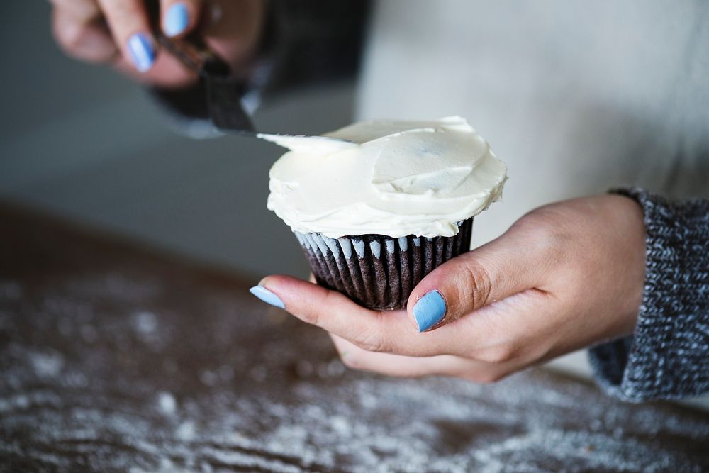 Woman frosting a cupcake