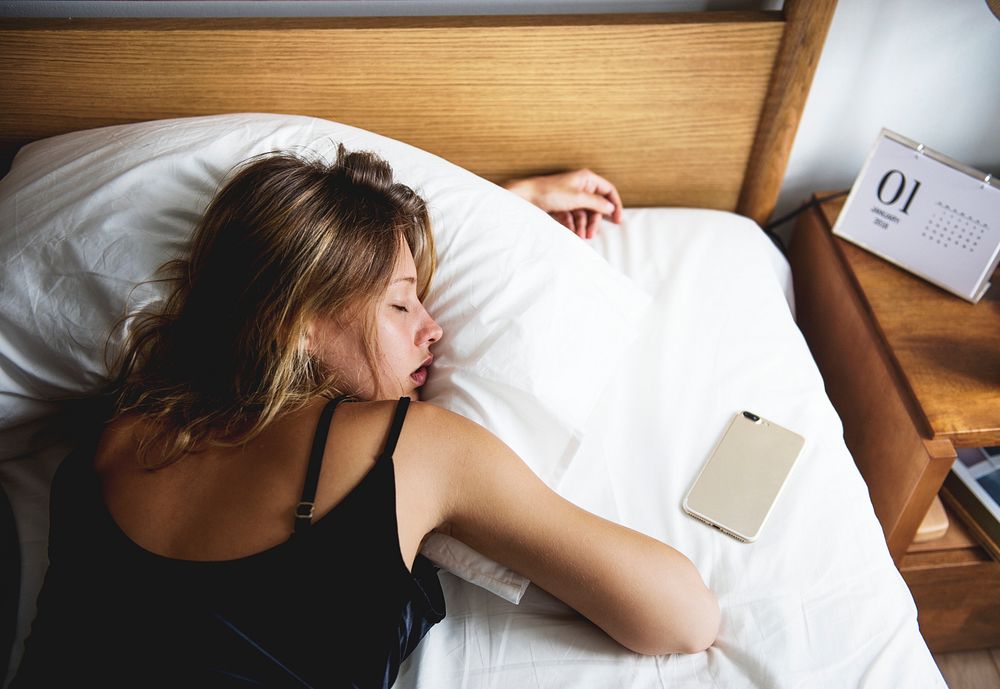 A Caucasian woman sleeping on her bed