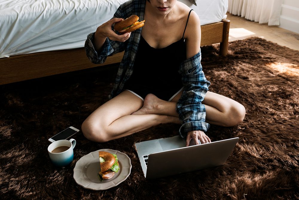 Woman using her laptop on the bedroom floor