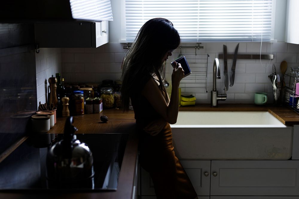 Girl drinking coffee alone in the kitchen
