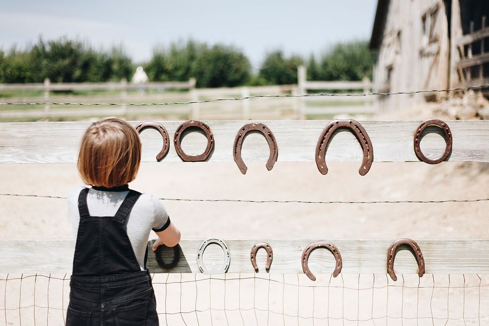 Little girl playing with horseshoe