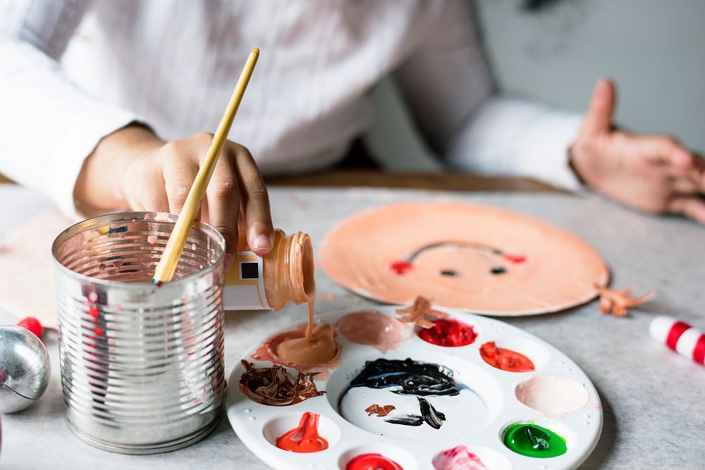 Kid painting Santa on a paper plate
