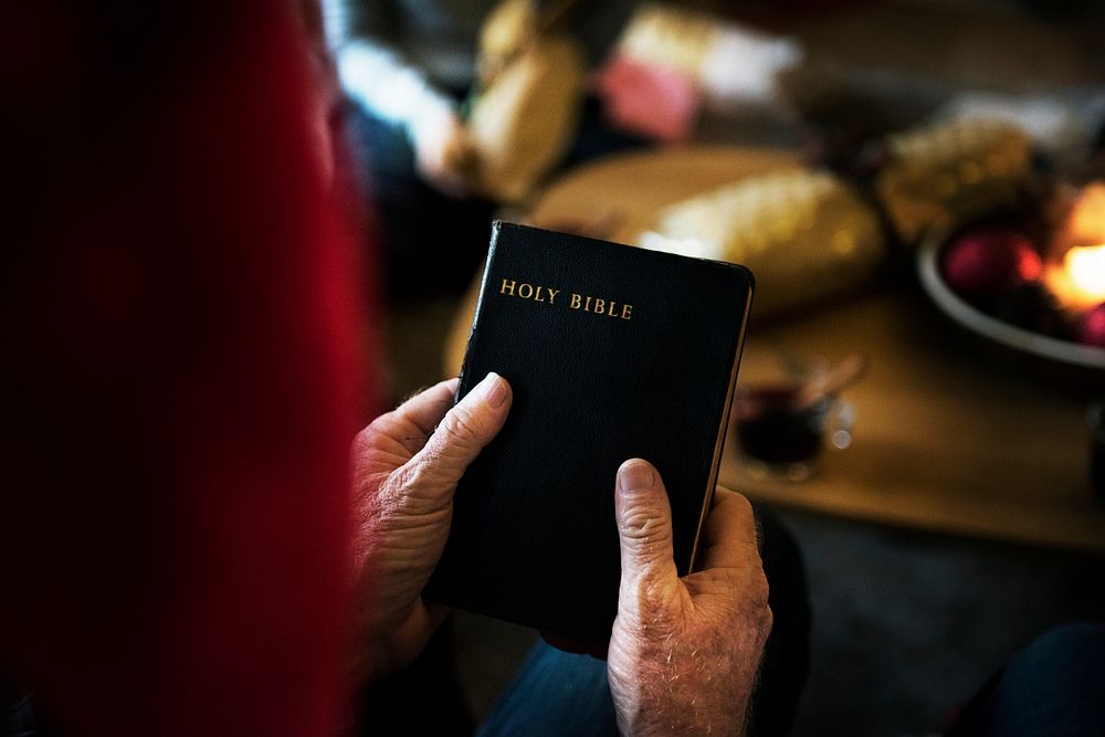 A person holding Holy Bible