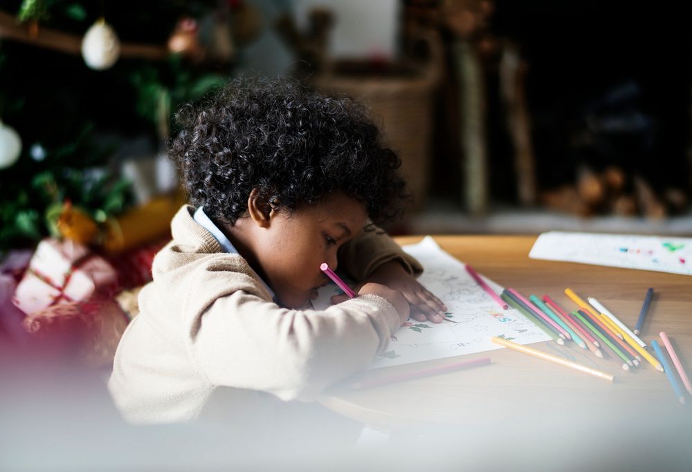 African kid enjoying a coloring book