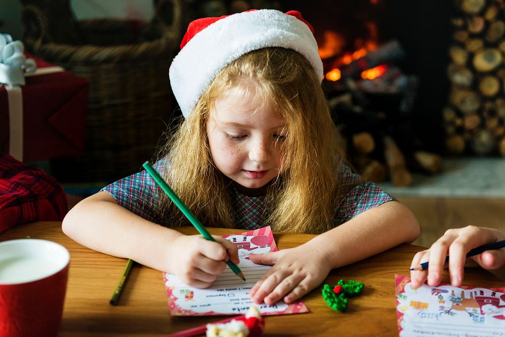Little girl writing a Christmas wishlist