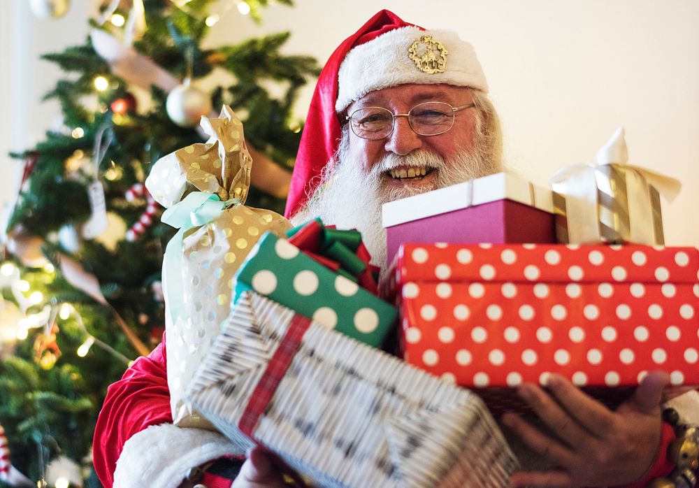 Santa Claus carrying a lot of Christmas presents