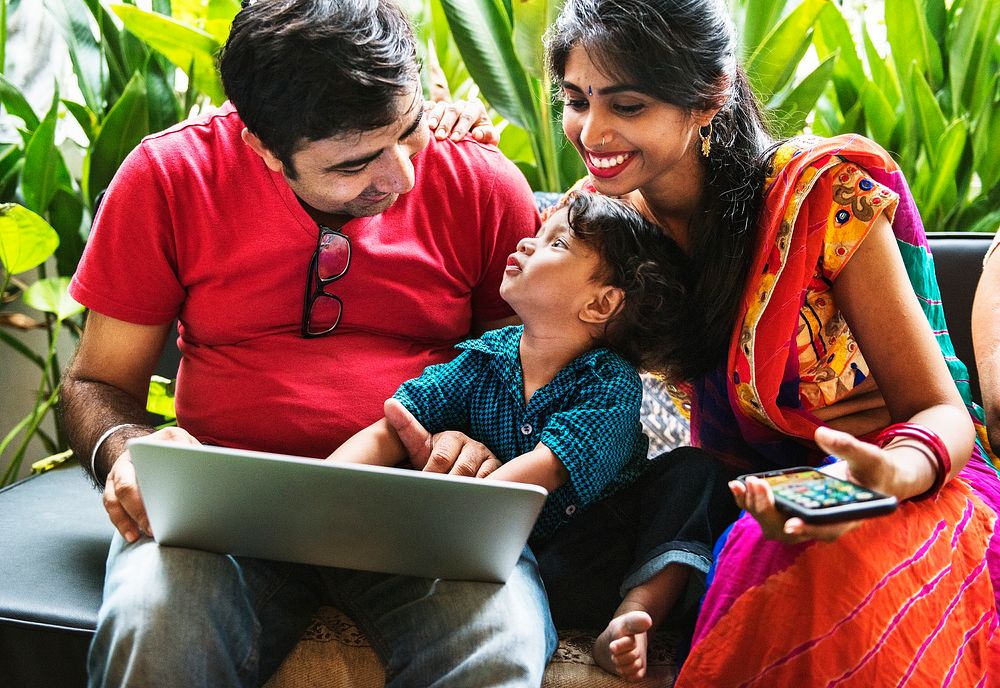 Happy Indian family using a laptop