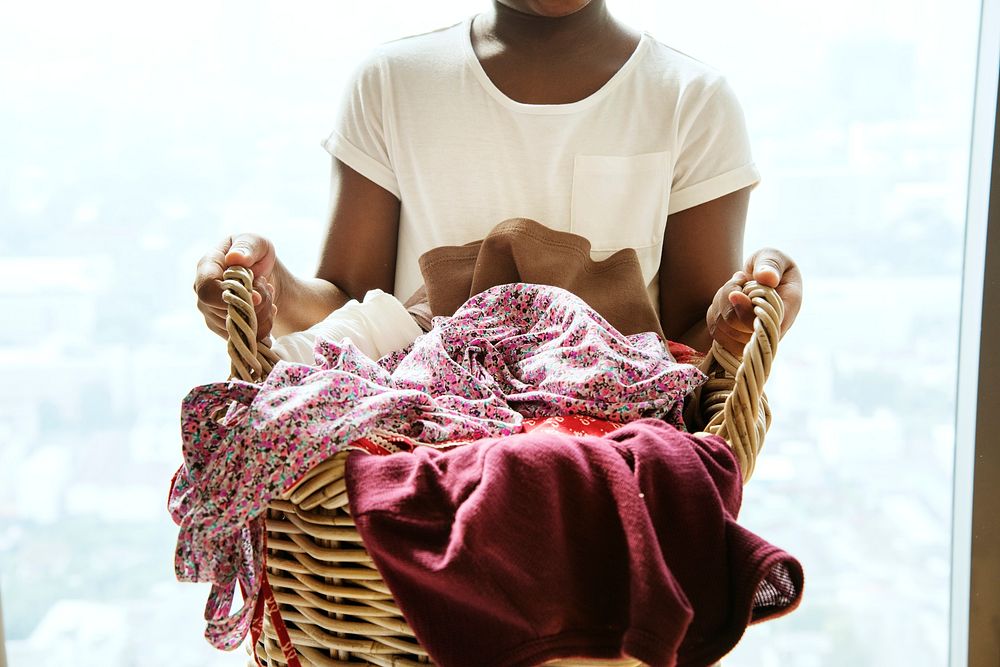 Young teen girl holding laundry basket