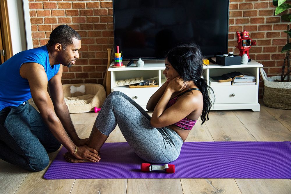 Black couple exercise at home together