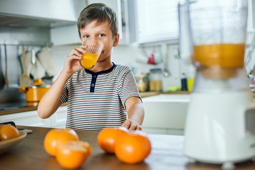 Young Caucasian boy drinking orange juice