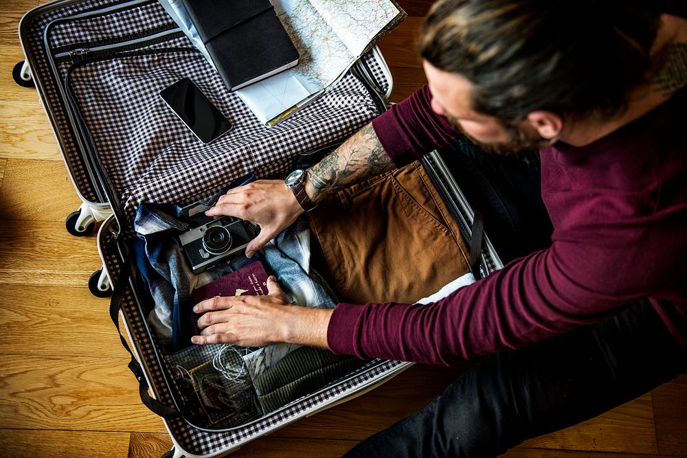 Caucasian man packing luggage for a trip