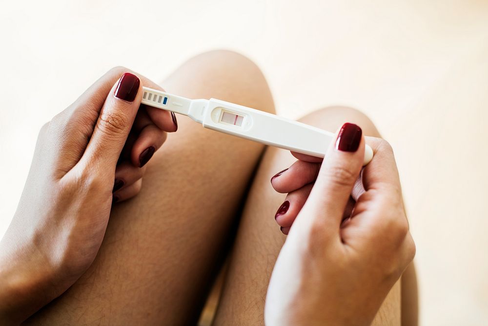Woman holding a negative pregnancy test