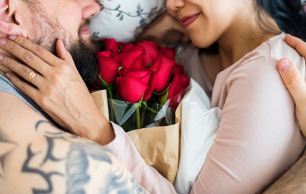 Husband surprised wife with red rose bouquet