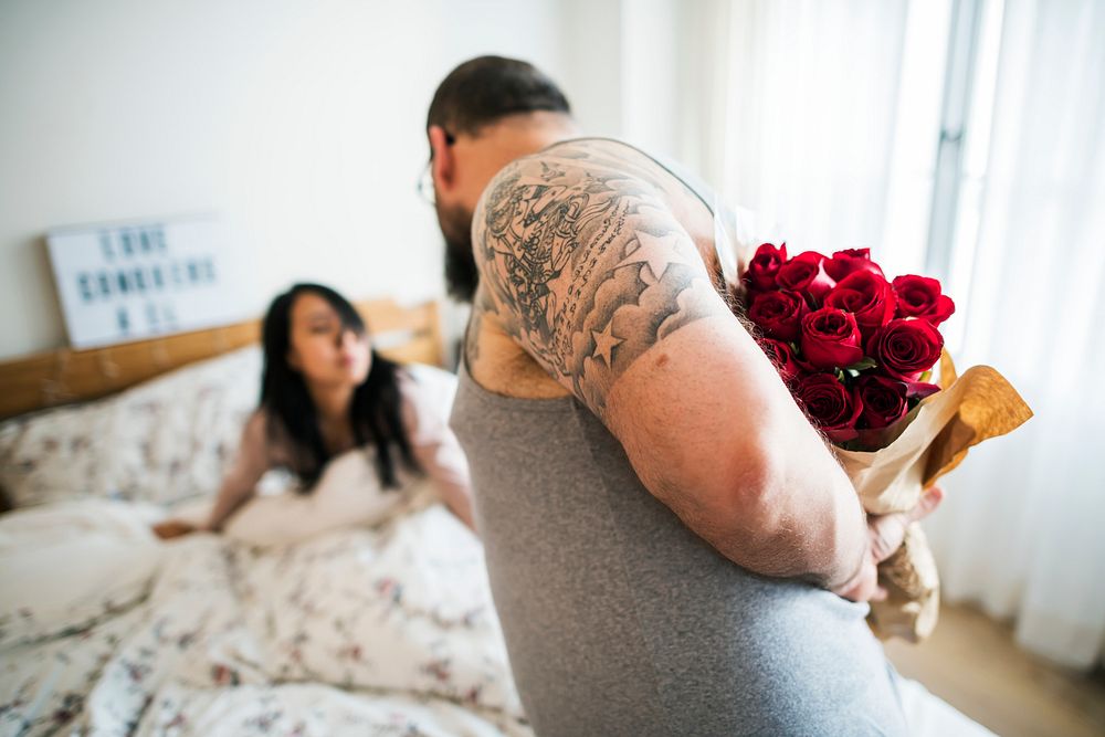 Husband surprised wife with red rose bouquet