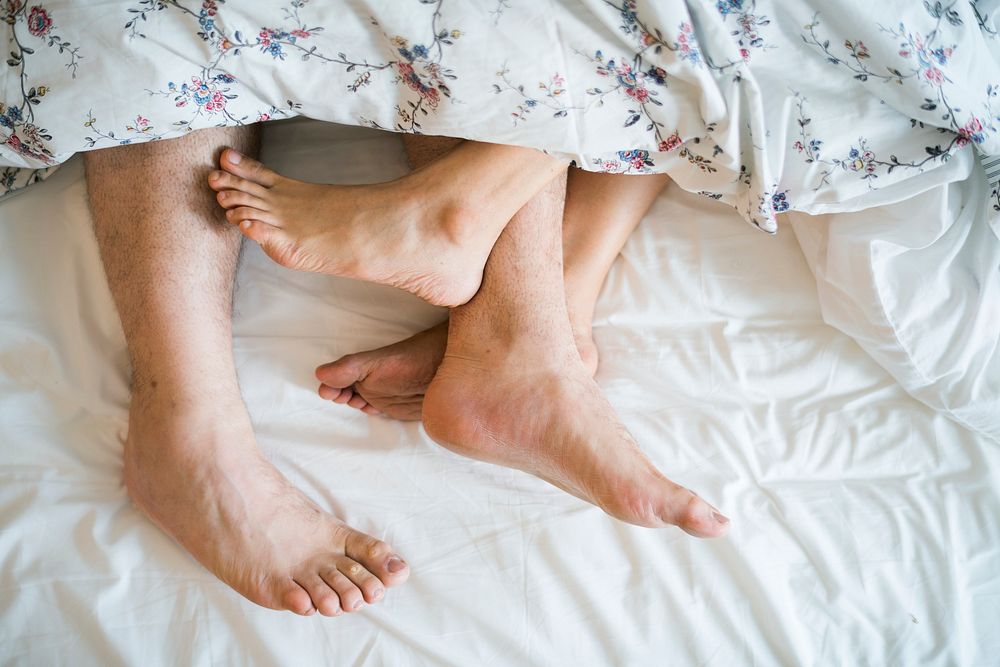 Aerial view of legs on bed