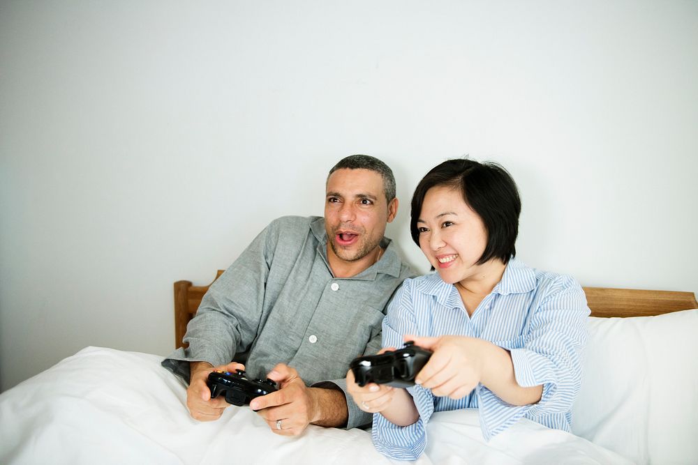 A couple playing game together in bed