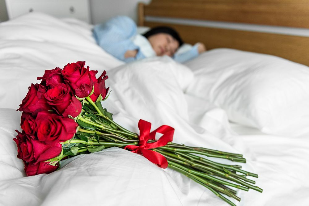 Closeup of a surprise bouquet of roses on the bed